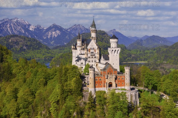 Neuschwanstein Castle with majestic Alpine peaks in the background, shrouded in clouds, Schwangau,