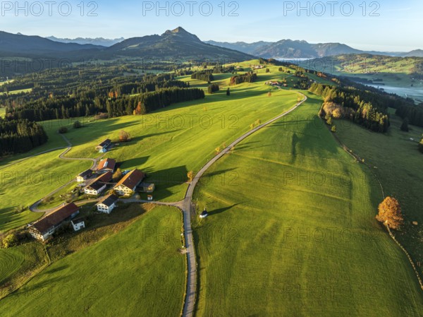 Mountain range near village Wertach, view to mt. Gruenten, sunrise, fog in valley, traditional
