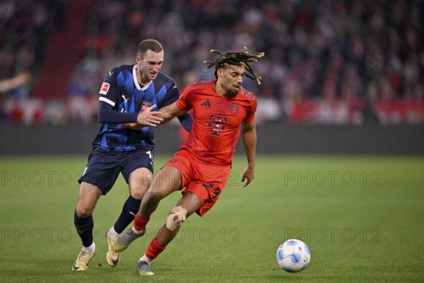 Duel, action Sacha Boey FC Bayern München FCB (23) against Jonas Föhrenbach 1. FC Heidenheim 1846