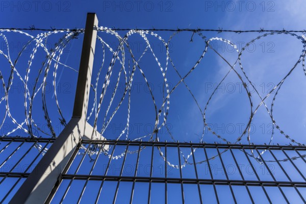 Symbolic image security, S-wire rolls, NATO wire, on a fence top, demarcation of a property,
