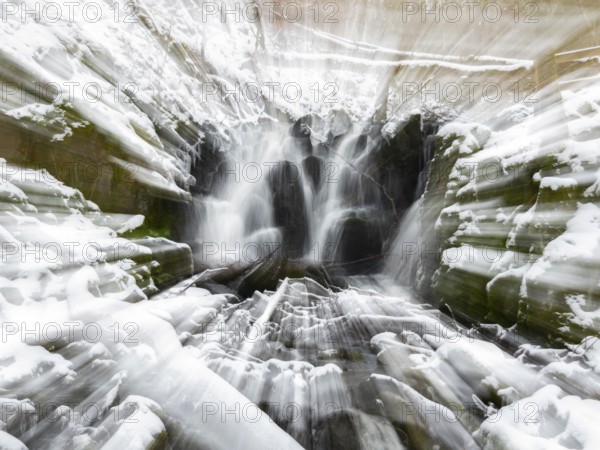 Abstract image of the Teufelsmühle waterfall on the hill stream the Schwartzbach, in snow and ice