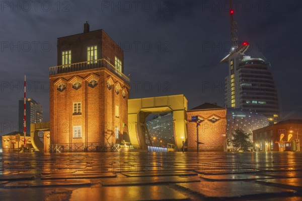 View of the old bascule bridge, the Klimahaus and a hotel in Bremerhaven at night, Bremerhaven,