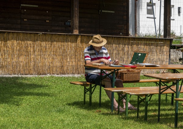 Hobby painter in an empty beer garden, Murnau, Bavaria, Germany, Europe