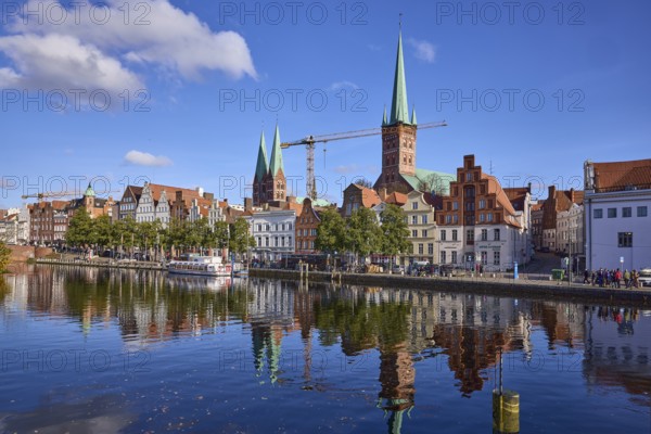 River Trave with quay wall, historical buildings, church towers of St. Marien and St. Petri,