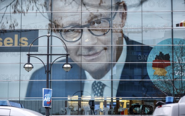 An AfD poster hangs in front of the portrait of CDU chancellor candidate Friedrich Merz at the CDU