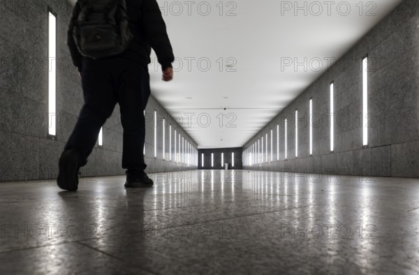 A man walks through the tunnel subway illuminated with LED light to the underground station Museum