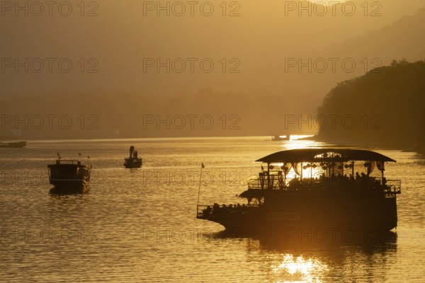 Sunset on the Mekong with excursion boats, near Luang Prabang, Laos, Asia