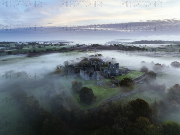 Raglan Castle in the fog at dawn from a drone, Monmouthshire, Wales, England, United Kingdom,