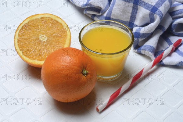 Orange juice in glass and orange, straw