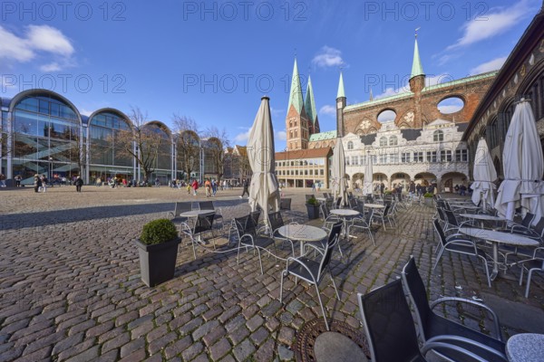 Church tower of St. Marien zu Lübeck, outdoor area of Café Niederegger - arcade café with tables,