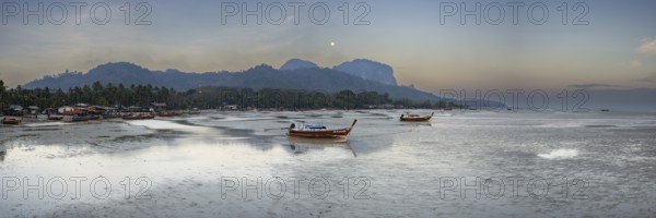 Before sunrise, longtail boats lie at low tide in the harbour at Sivalai Beach, Koh Mook Island,