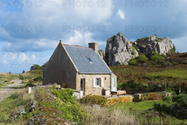 Lonely house in a rural landscape with rocks under a cloudy sky, Plage de Pors Scaff, Plougrescant,