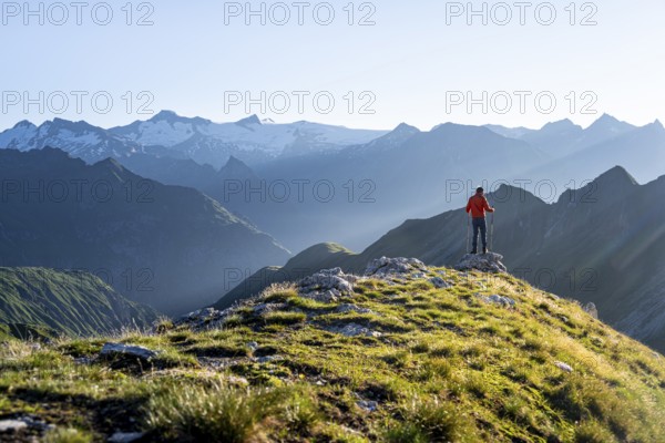 Hiker enjoying the mountain panorama in the morning, Venediger group, behind Dreiherrenkopf,