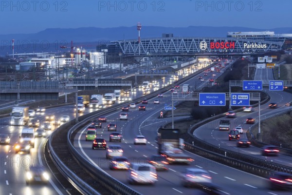 Heavy traffic in the evening on the A8 motorway at the airport. In the background, the Bosch bridge