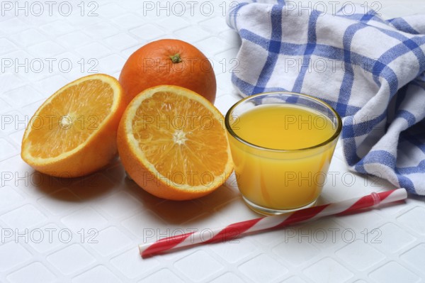 Orange juice in glass and orange, straw