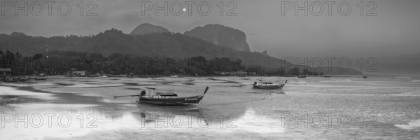 Before sunrise, longtail boats lie at low tide in the harbour at Sivalai Beach, Koh Mook Island,