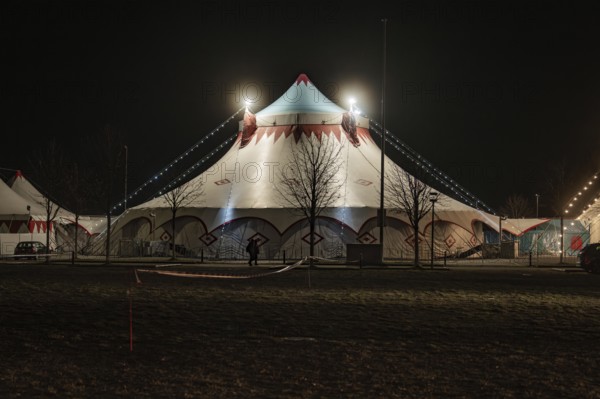 Standard illuminated circus tent at night with bare trees, Böblingen, Germany, Europe