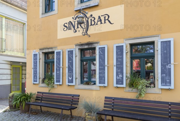 Exterior view of the Sinkbar pub with labelled shutters, village green of Altkötzschenbroda,