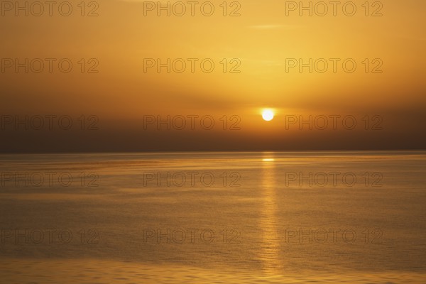 Setting golden sun over Adriatic sea taken from the top deck of a cruise ship in late summer, near