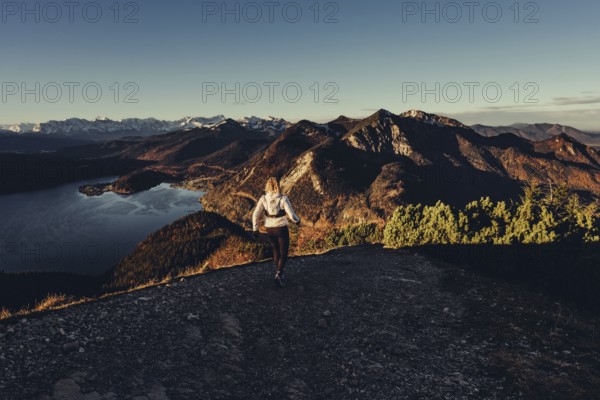 Trail running in autumn on the Jochberg on Lake Walchensee against the wonderful backdrop of the