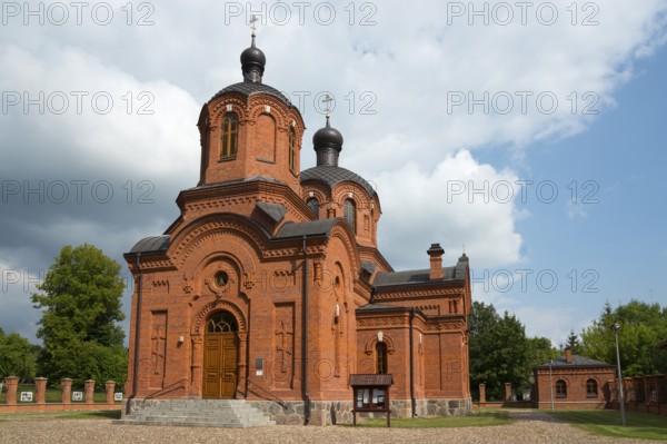 Red brick church with high towers and cloudy sky in the background, Orthodox Church of St Nicholas,