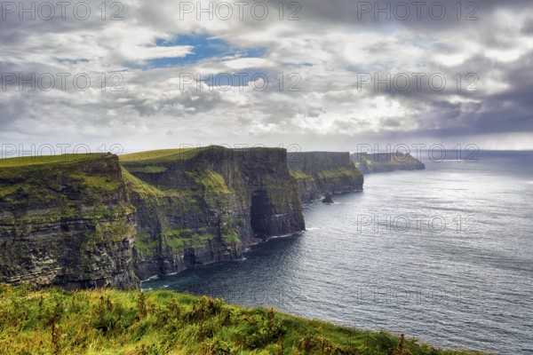 Cliffs of Moher in the haze, rain clouds on the horizon, Ireland, Europe