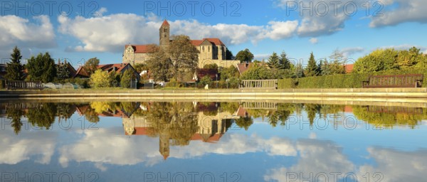 Castle hill with collegiate church of St. Servatius with reflection in water basin in autumn,