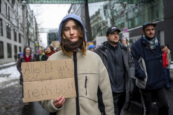 Woman with sign: Everything's fine as long as you're rich! Quote from Die wilden Kerle. At the