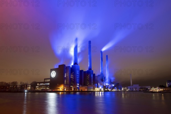 Illuminated cogeneration plant of Volkswagen, Volkswagen logo, the sky is bathed in blue,