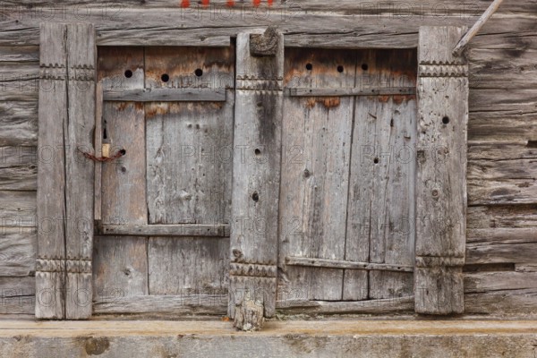 Closed wooden window shutter. Historic village of Mühlebach, Valais, Switzerland, Europe