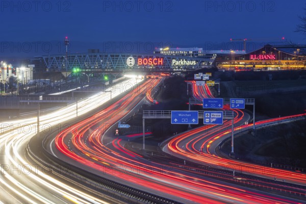 A8 motorway at Stuttgart Airport in the evening. Heavy traffic, lanes of light. Modern architecture