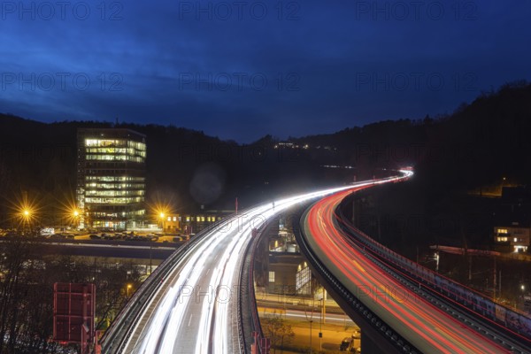 Federal road B14 at night, road bridge with traffic and light lanes. On the left the building of