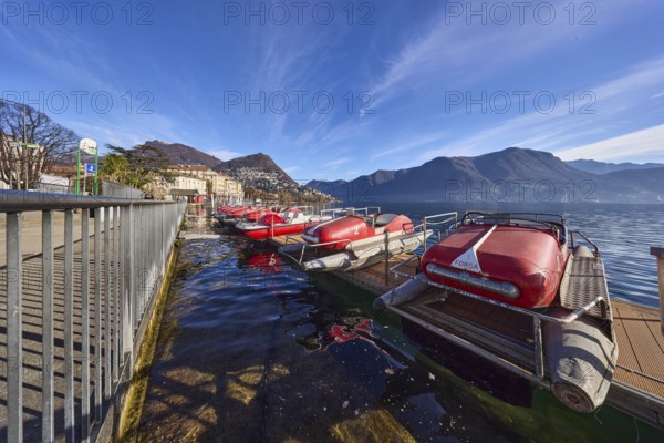 Pedal boats, metal railing, lake, shore, pavement, pedal boat rental, mountain landscape, haze,