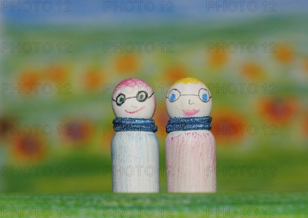 Two small funny wooden cones in front of a painted background, North Rhine-Westphalia, Germany,