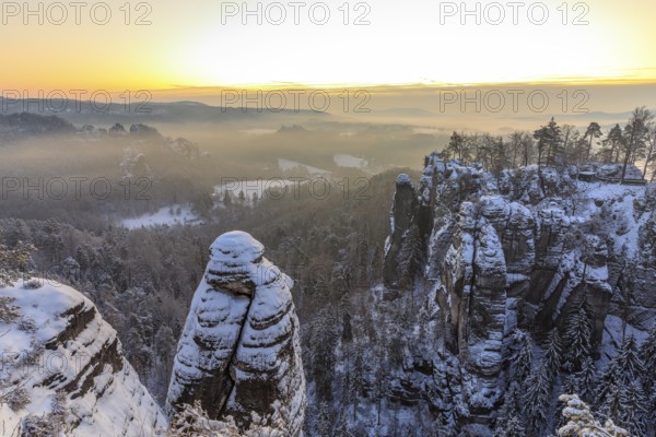 View from the Ferdinandstein into the Wehlgrund and to the rock castle Neurathen near snow, Bastei,
