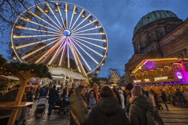 Ferris wheel at the winter village, Christmas market at dusk, St Elisabeth's Church on the right,