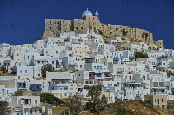 White houses on a hill under a blue sky, overlooked by a castle, Querini Castle, Chora, Astypalea,