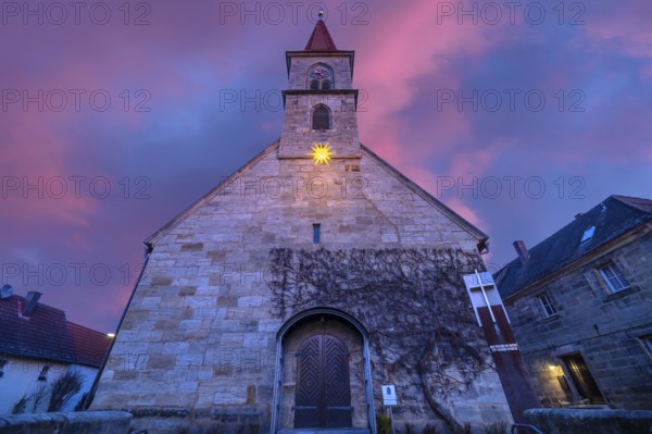 St Bartholomew's Church with poinsettia at dusk, Eschenau, Middle Franconia, Bavaria, Germany,