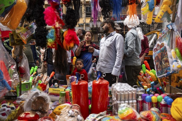 People buy Holi celebration items in a market on the eve of Holi Festival, on March 13, 2025 in