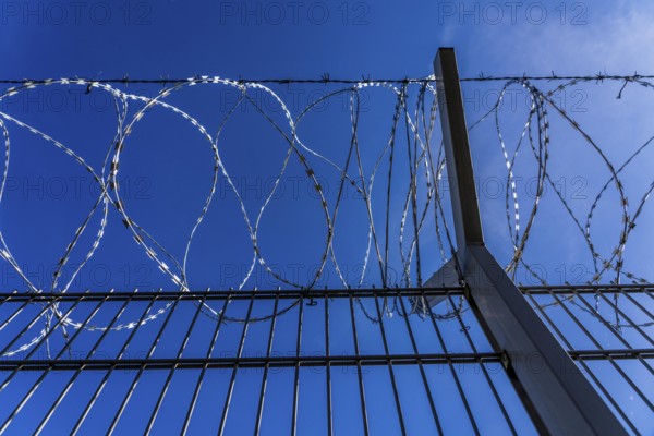 Symbolic image security, S-wire rolls, NATO wire, on a fence top, demarcation of a property,