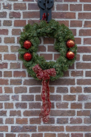 Door wreath as a Christmas decoration in front of a brick wall, Münsterland, North