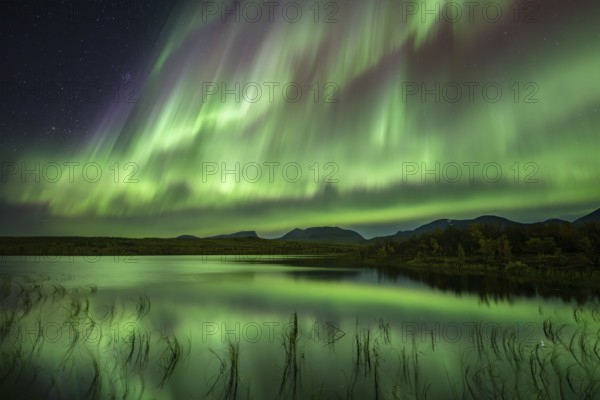 Northern lights reflected in lake, Lapporten, Abisko National Park, Lapland, Sweden, Europe