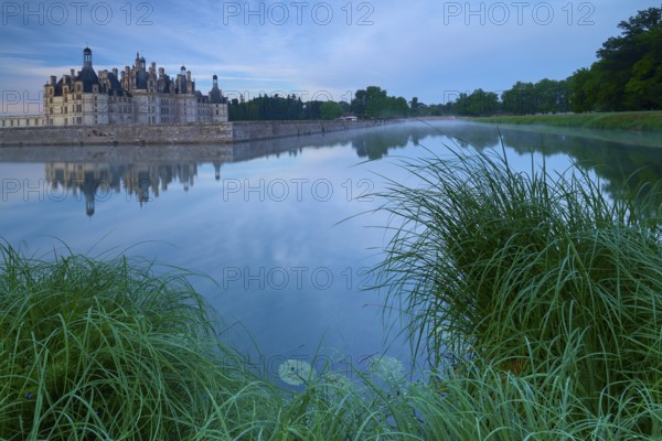 Chambord Castle with moat at sunrise, Chambord, Department Loir-et-Cher, Centre region, France,