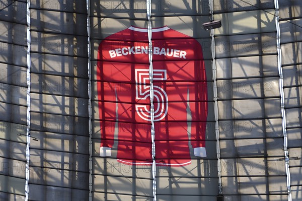 Larger-than-life jersey of Franz Beckenbauer with shirt number 5 hanging in the grandstand roof of