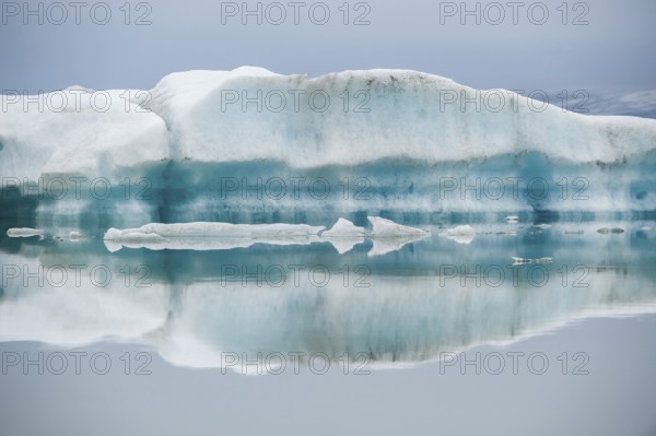Ice formations are reflected in the still, misty water, Jökulsárlón glacier lagoon or Jökulsarlon,
