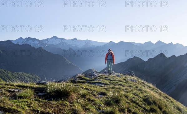 Hiker enjoying the mountain panorama in the morning, Venediger group, behind Dreiherrenkopf,