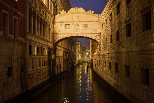 View from 'Ponte della paglia' on the bridge 'Bridge of Sighs' over a waterway at the blue hour in