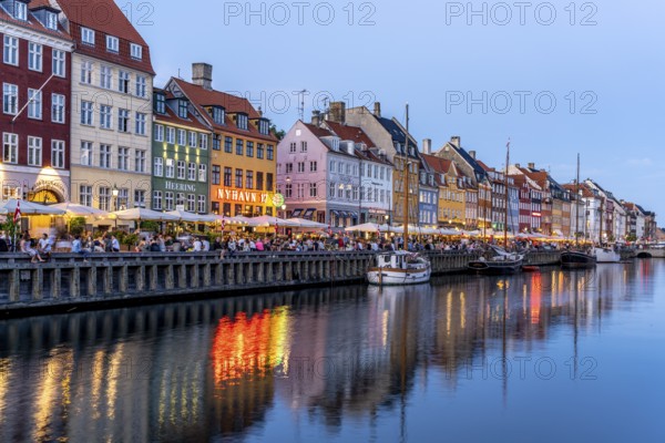 Colourful houses, restaurants and historic ships on the Nyhavn canal and harbour at dusk,