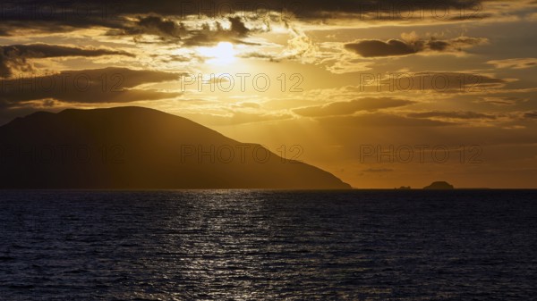 Dramatic sunset over the sea, island visible as a silhouette, Kassos island, neighbouring island