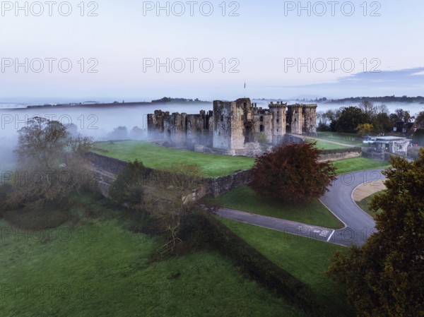 Raglan Castle in the fog at dawn from a drone, Monmouthshire, Wales, England, United Kingdom,